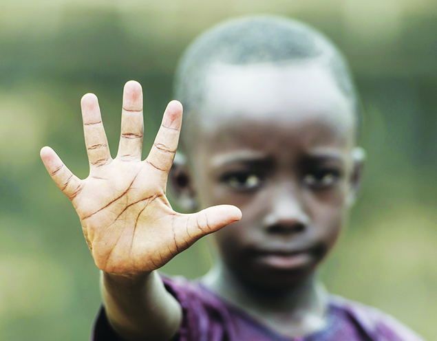 African boy holding his hand up to the camera