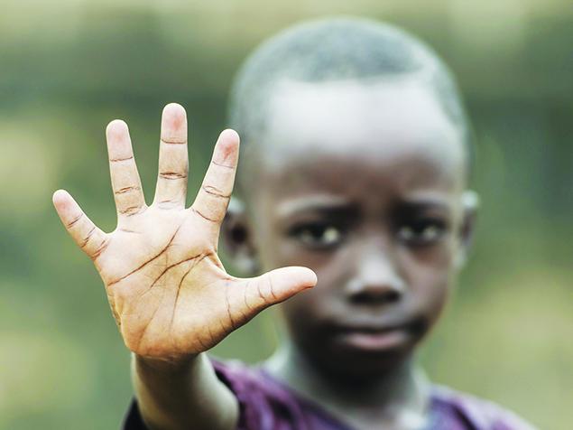African boy holding his hand up to the camera