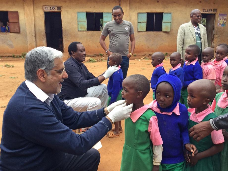 Prof Raman Bedi inspecting a child's mouth